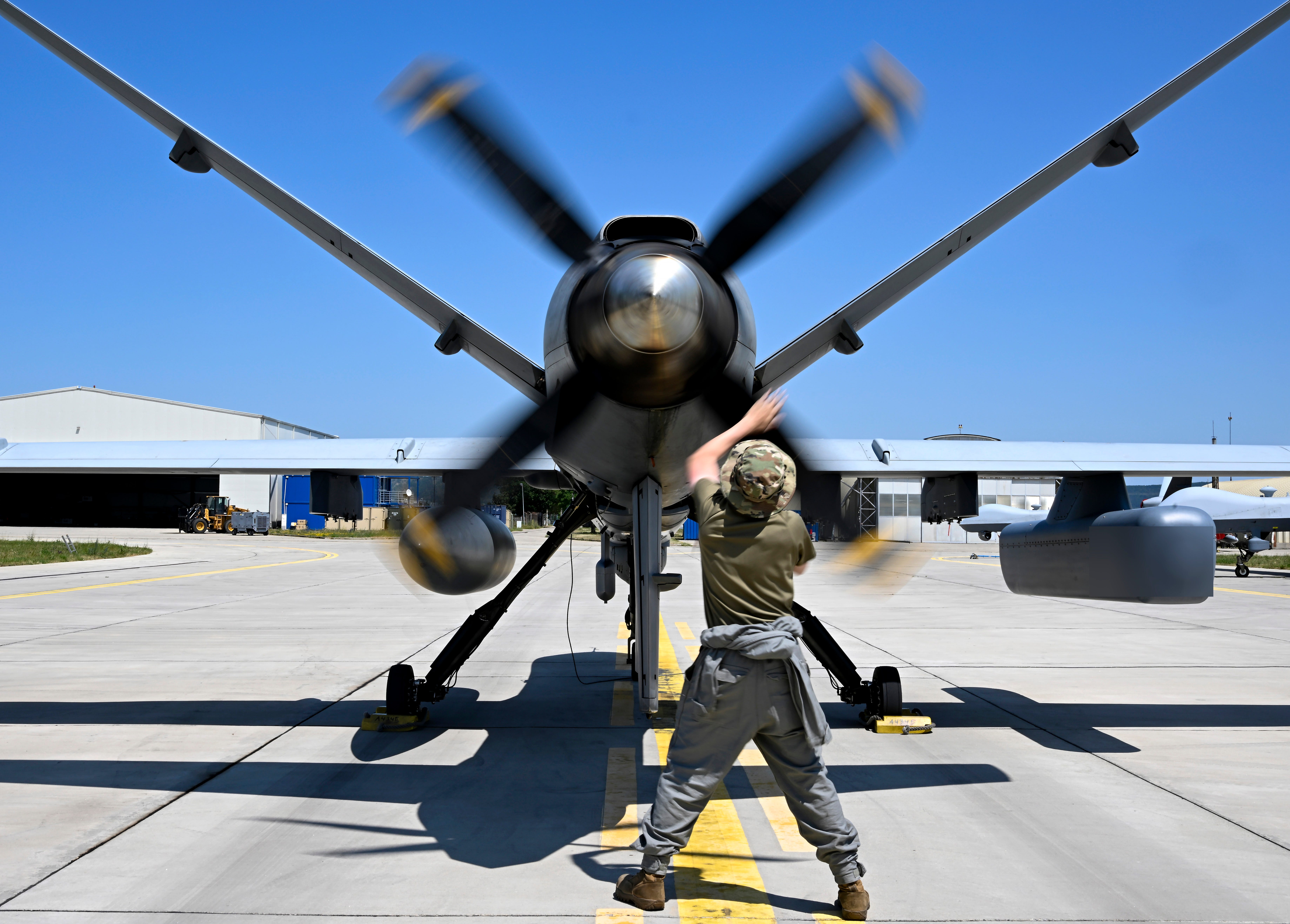 Senior Airman Jeremy Erwin, 731st Expeditionary Attack Squadron crew chief, spins and inspects the props on an MQ-9 Reaper to ensure it spins freely at Câmpia Turzii, Romania, in June 2025.