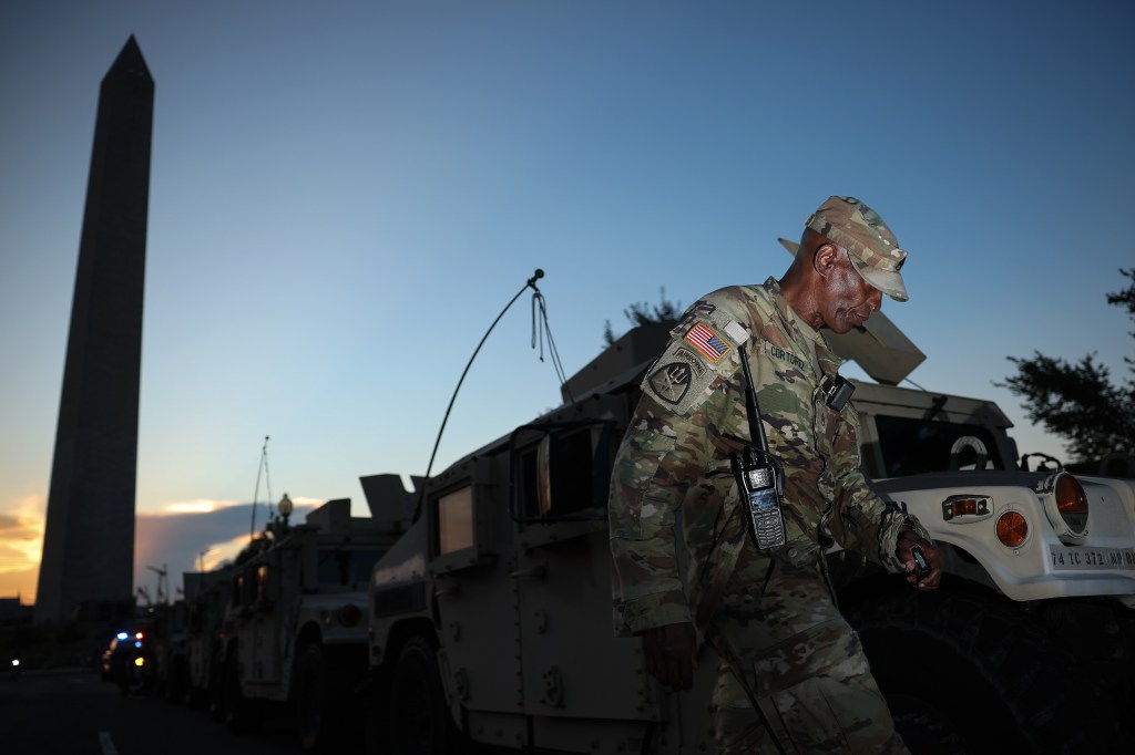 A member of the DC National Guard joins his unit near the Washington Monument in Washington, DC, on Aug. 12, 2025.