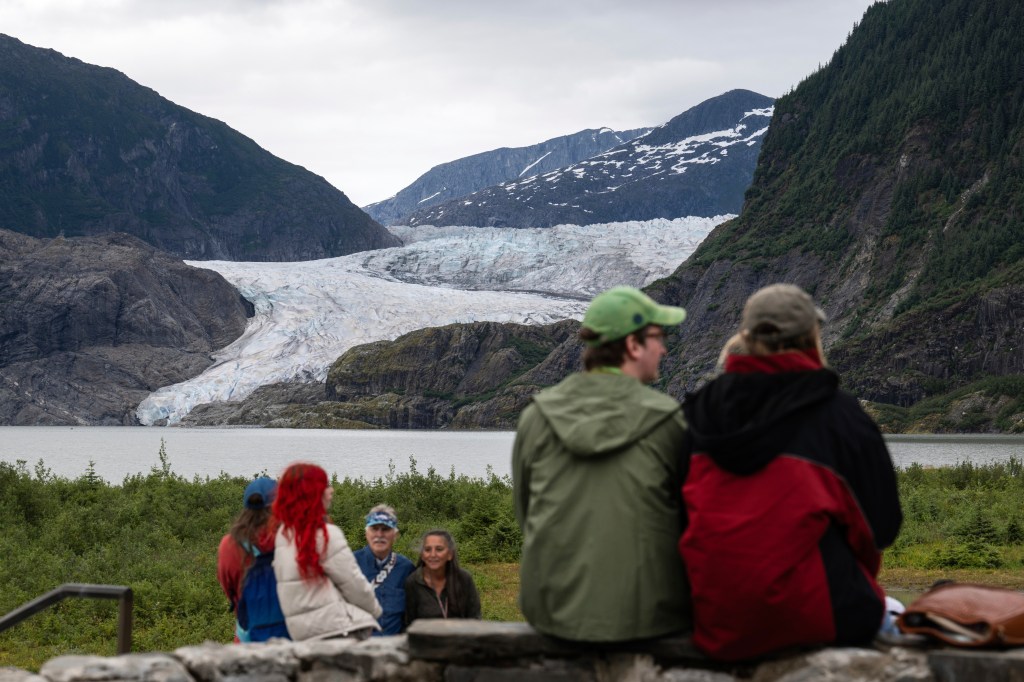 People look out at Mendenhall Glacier from the Mendenhall Glacier Visitors Center on Aug. 3, 2025.