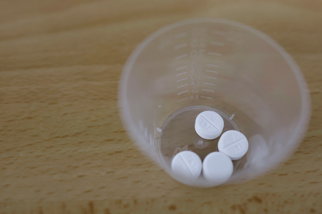 Photo illustration of Misoprostol tablets in a small cup.