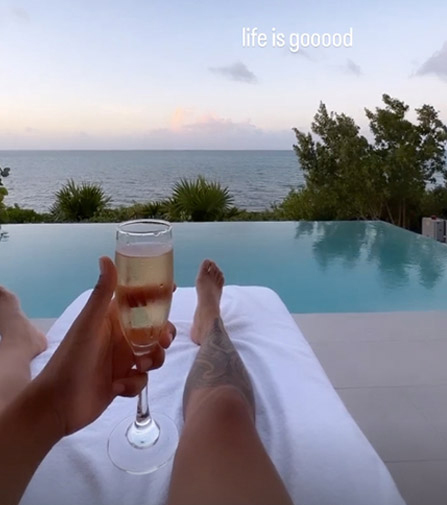 A photo posted to the former postal workers' Instagram shows her lounging by a pool with a glass of champagne while on vacation.