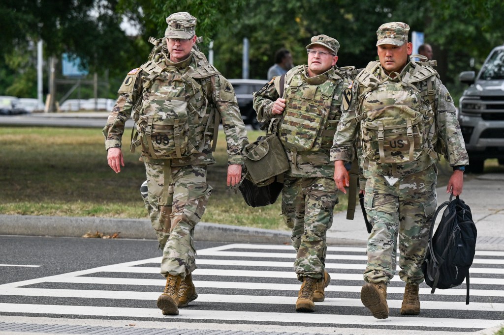 Members of the US National Guard walks towards the DC Armory to assist in crime prevention on Aug. 12, 2025.