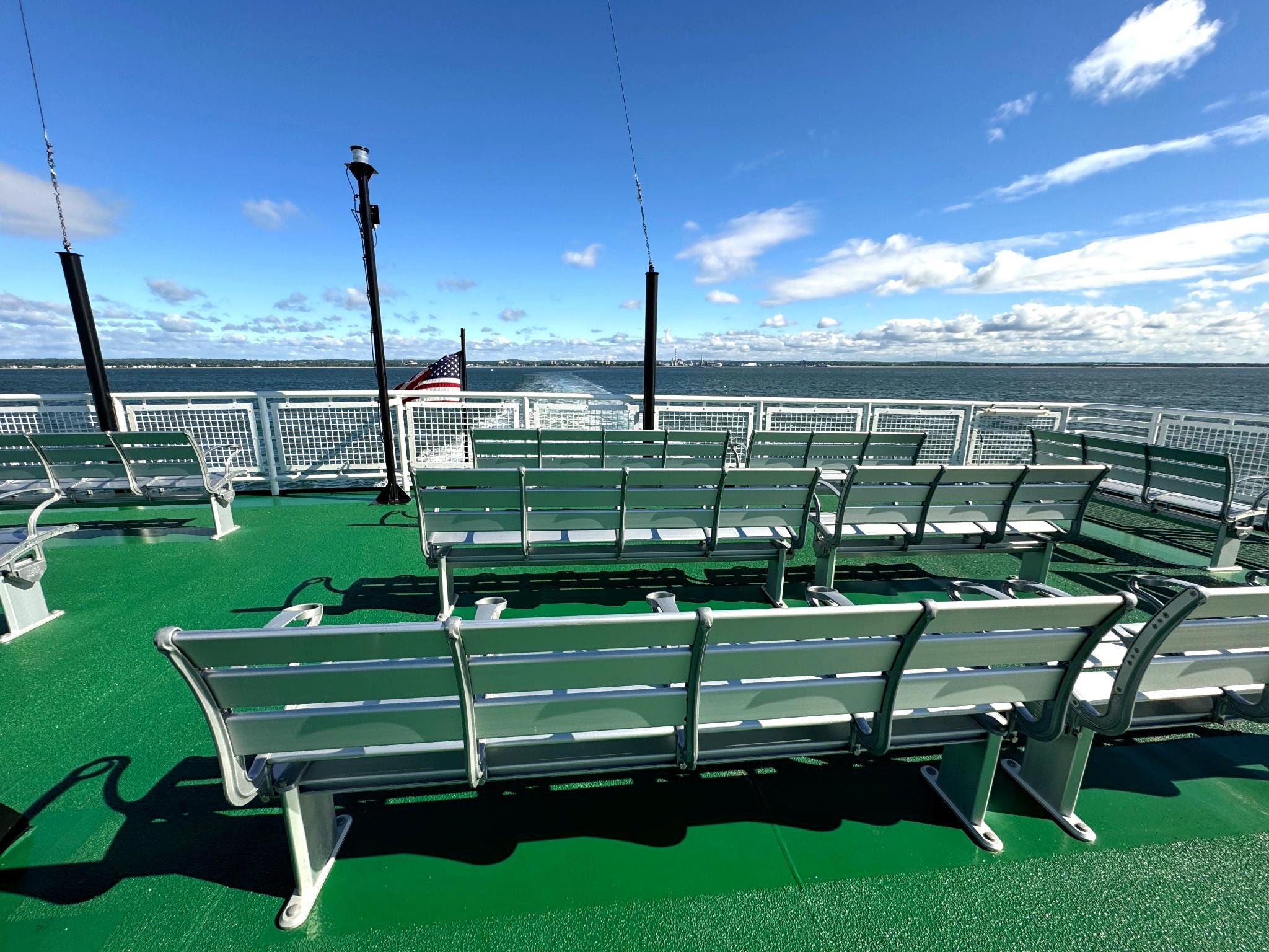 Empty benches on the top deck of a ferry.
