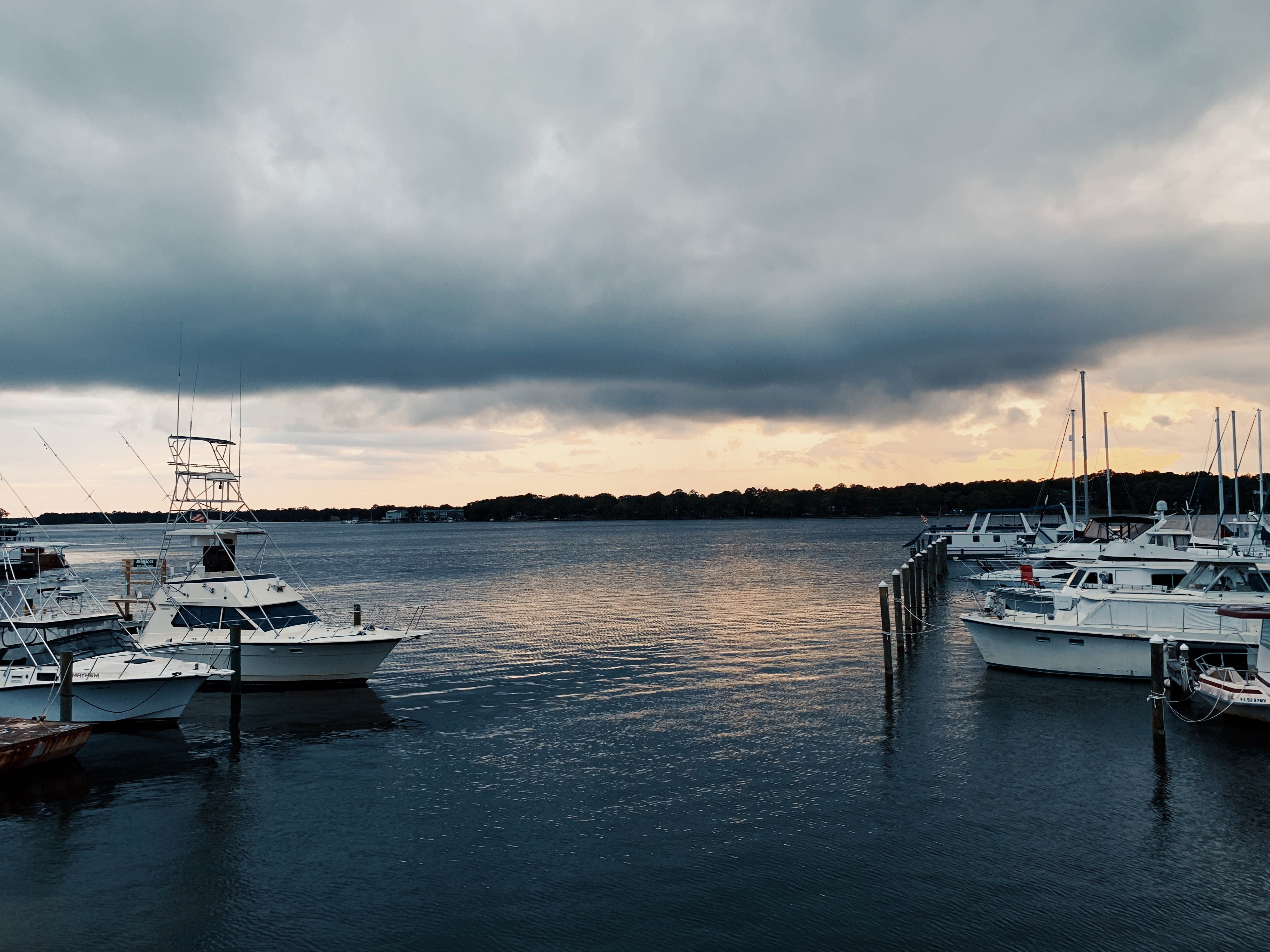 Ominous gray clouds over body of water with boats in it