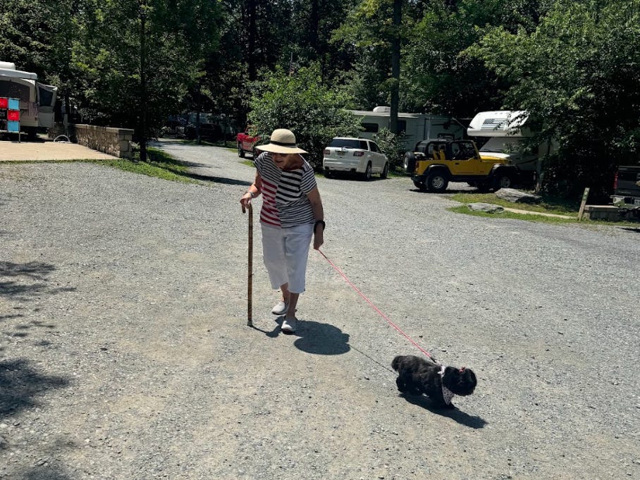The writer's grandmother walking the family's dog at a campsite.