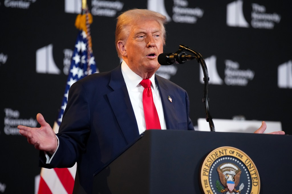 President Trump speaking at a podium at the Kennedy Center.