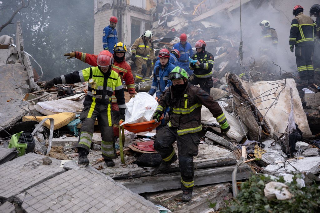 Rescuers removing a body from a destroyed building in Kyiv.