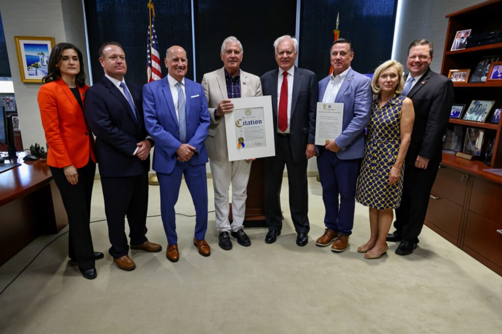 Group of people posing for a photo with a certificate.