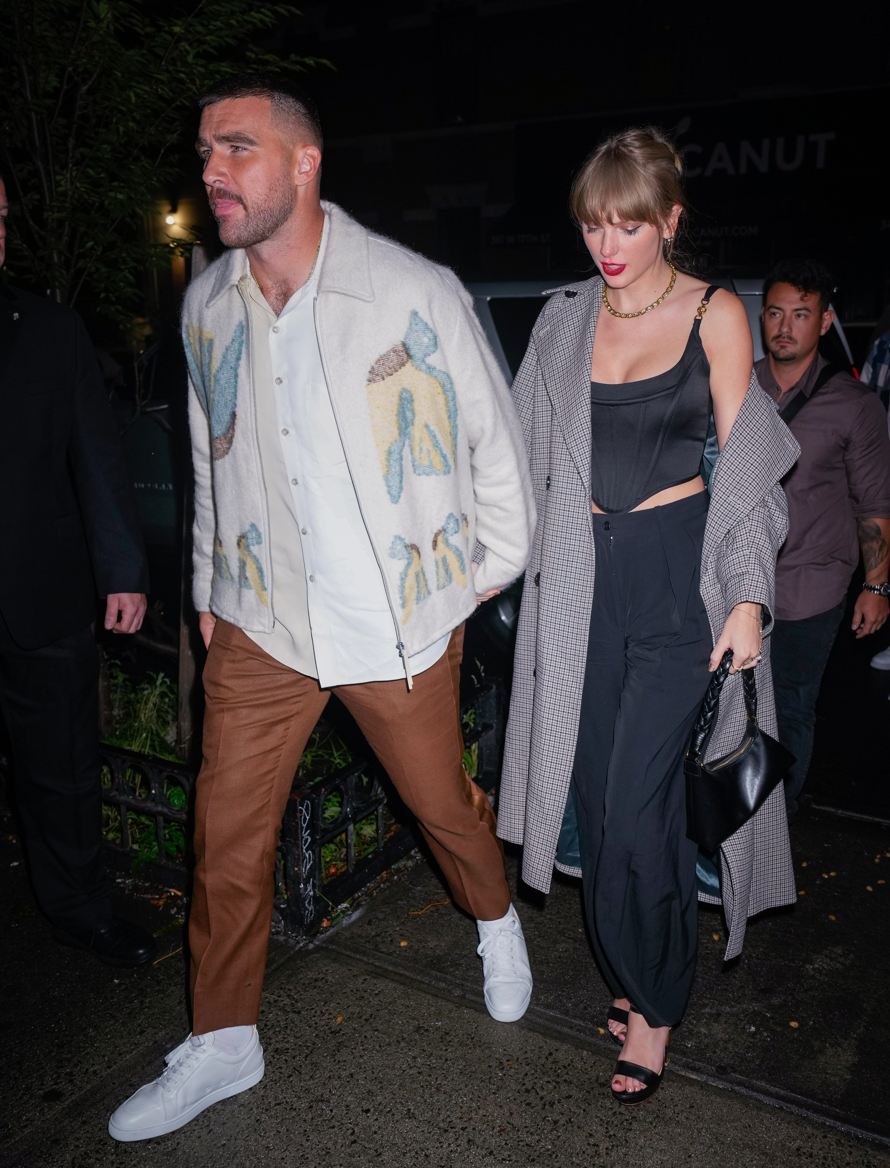Taylor Swift and Travis Kelce hold hands. 