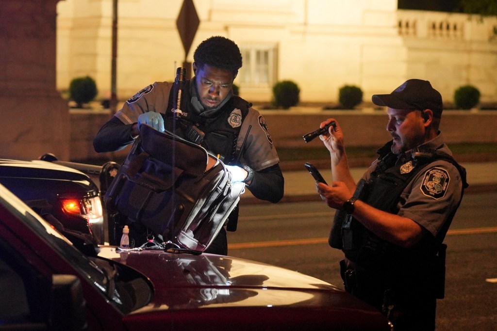 Police officers search a bag of a driver detained during a traffic stop.