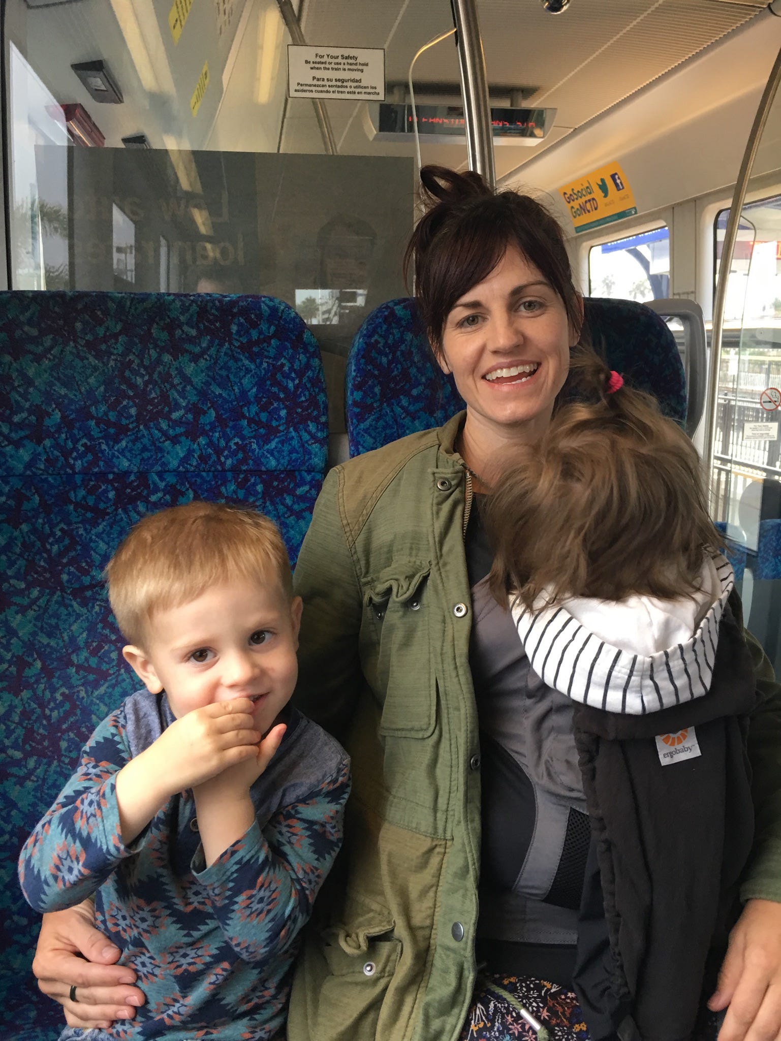 The author sitting with her two young kids on a bus.