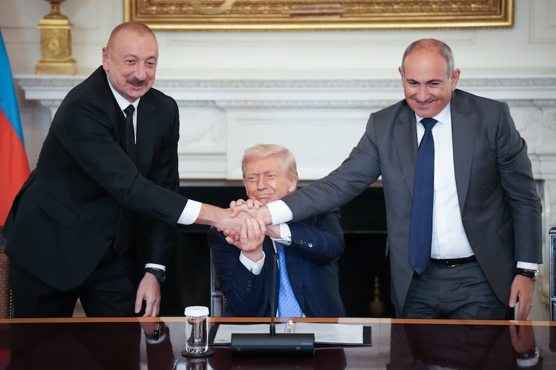 WASHINGTON, DC - AUGUST 08: U.S. President Donald Trump (C) joins hands with Azerbaijani President Ilham Aliyev (L), and Armenian Prime Minister Nikol Pashinyan (R) during a signing ceremony in the State Dining Room of the White House on August 8, 2025 in Washington, DC. The signed agreement is intended to bring an end to the conflict between Armenia and Azerbaijani that has lasted for decades.  (Photo by Andrew Harnik/Getty Images)