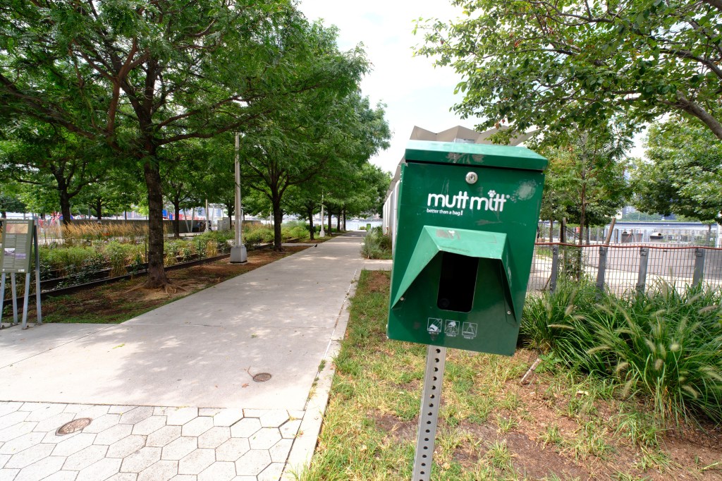 An empty dog waste bag holder near the dog park.