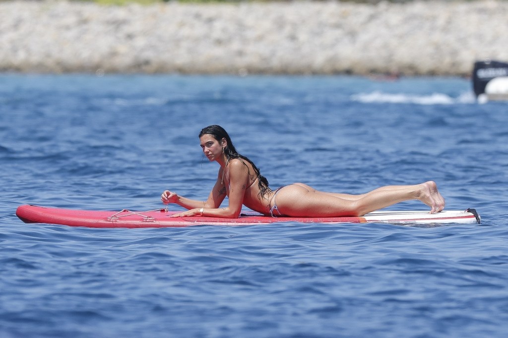 Dua Lipa doing yoga on a paddleboard in Ibiza.