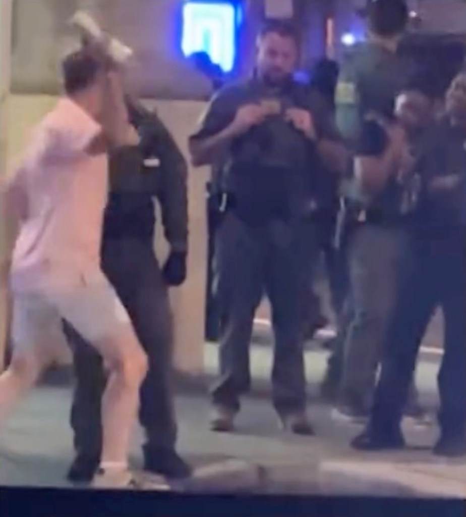 A man being apprehended by several police officers.
