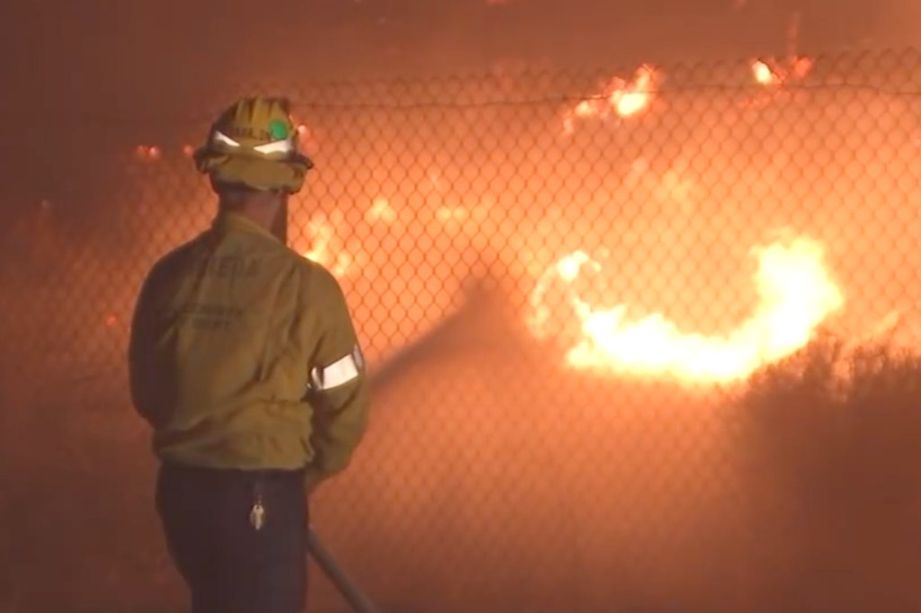 Firefighters were forced to shut down both sides of the freeway for a time as flames got dangerously close to the roadway.