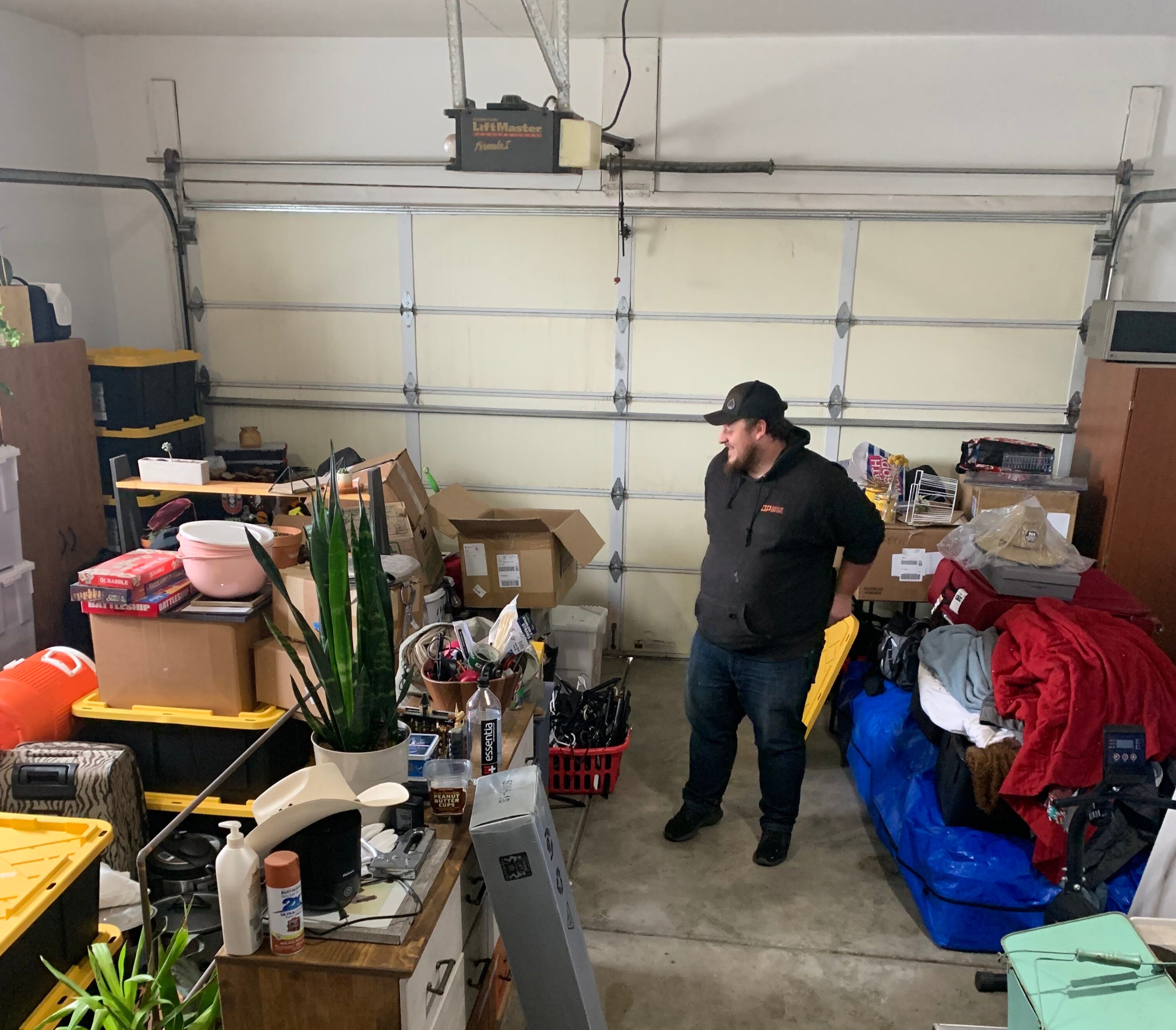 man standing in garage converted into a living space for a couple and their dog