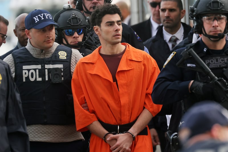 NEW YORK, NEW YORK - DECEMBER 19: Luigi Mangione, suspect in the killing of UnitedHealthcare CEO Brian Thompson in New York City, arrives at a heliport with members of the NYPD on December 19, 2024 in New York City.