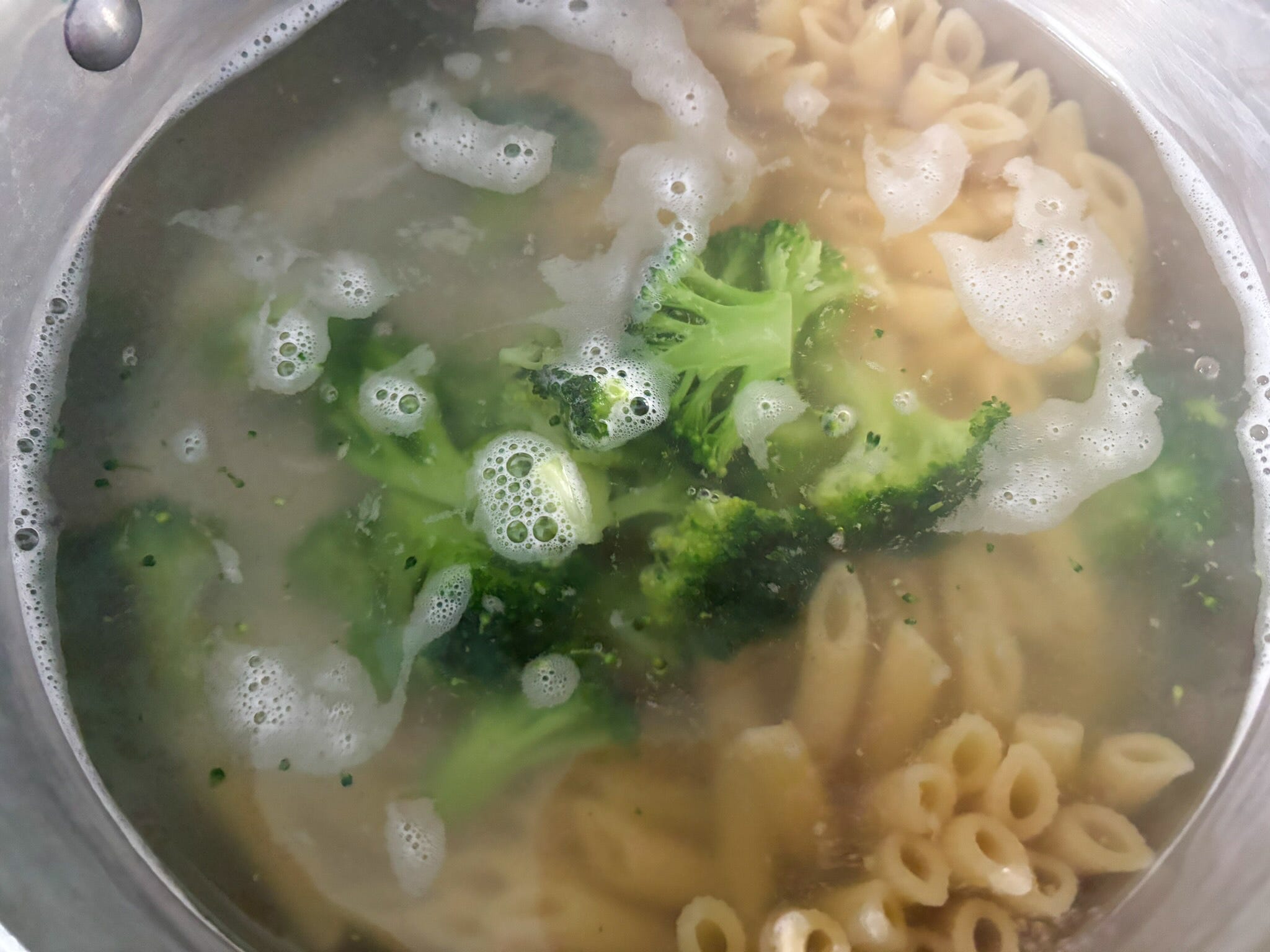 Broccoli added to the pot of pasta.