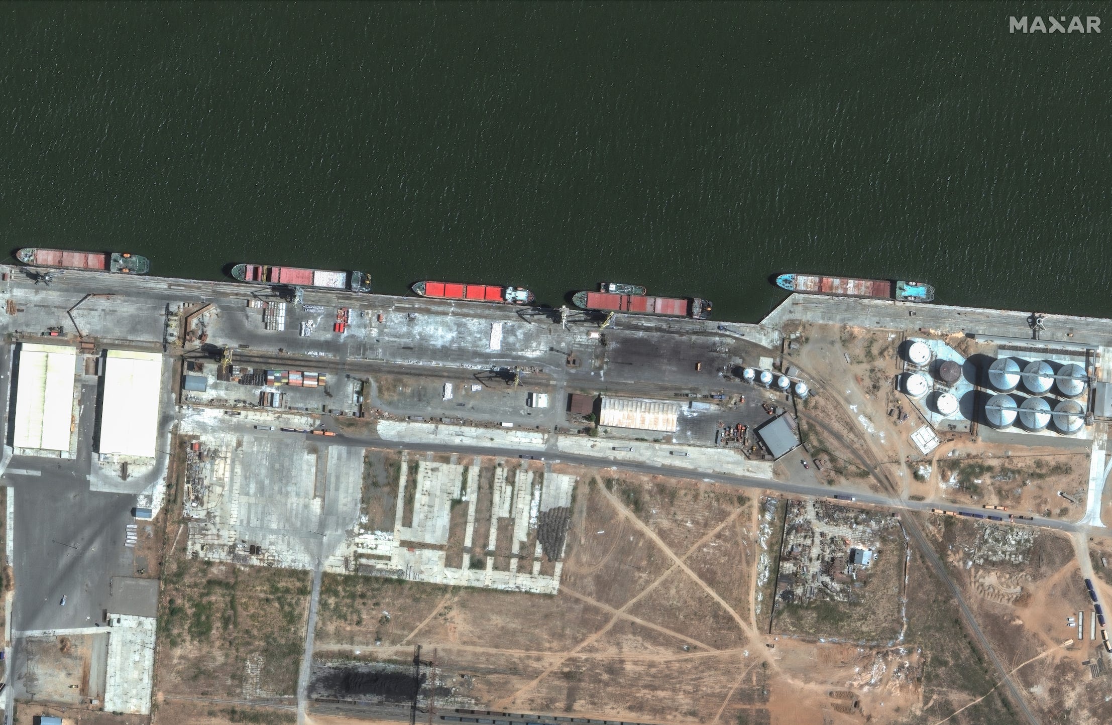 A satellite image of a port, where multiple cargo vessels can be seen.