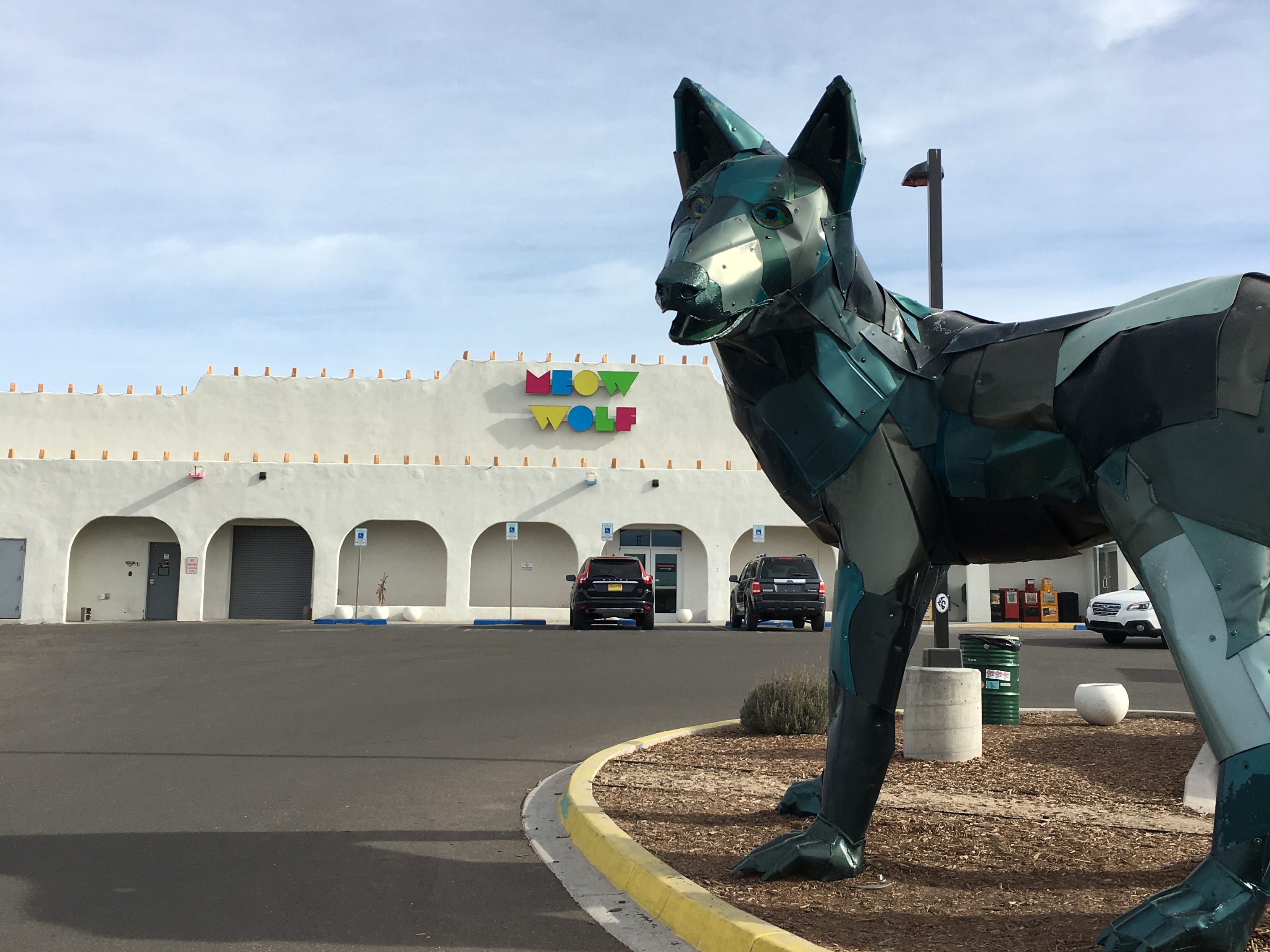 The exterior of Meow Wolf's House of Eternal Return with a large wolf sculpture in front.