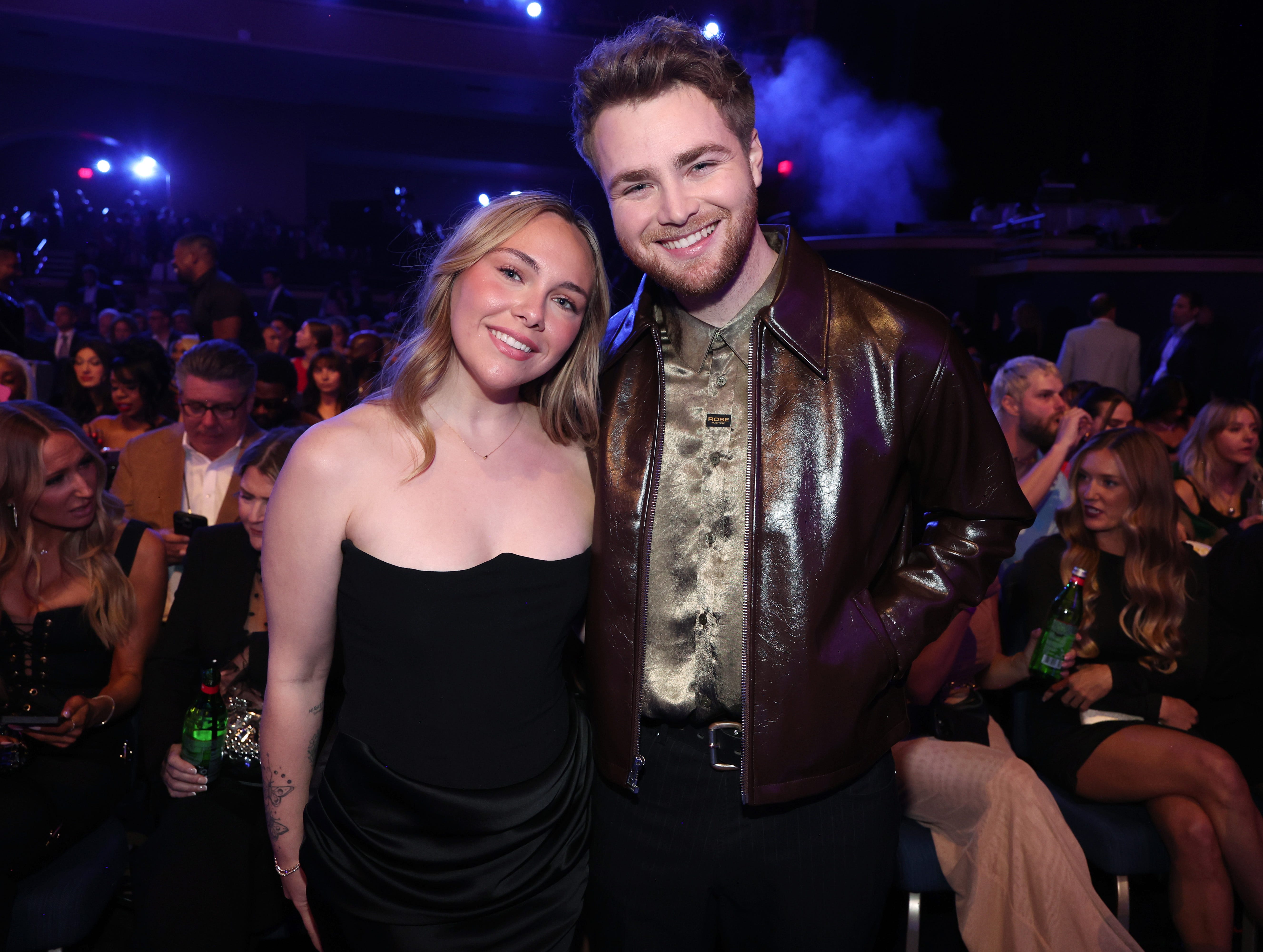 Alex Warren and wife Kouvr Annon standing in the audience at the 2025 American Music Awards.