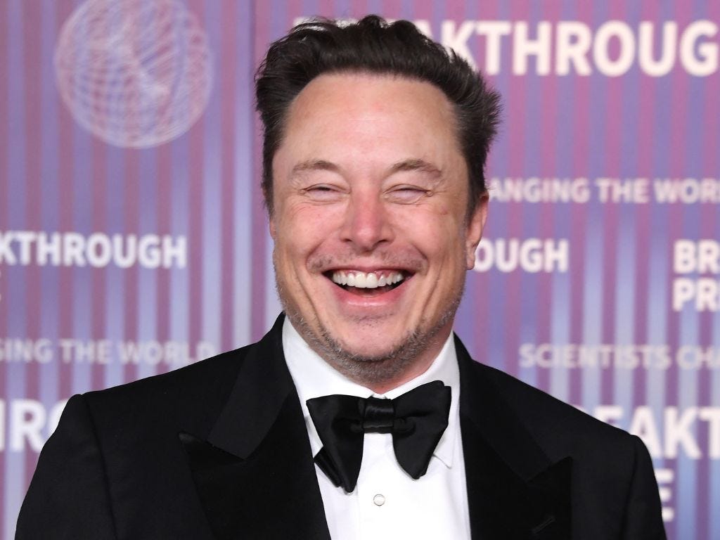 Elon Musk in black tie, laughing.