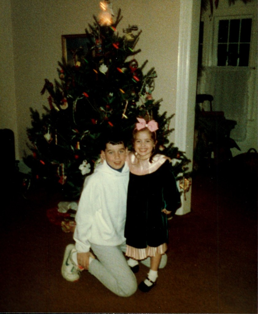 Photo of Ryan Fitzgerald and his sister Elizabeth Parks as children in front of a Christmas tree.