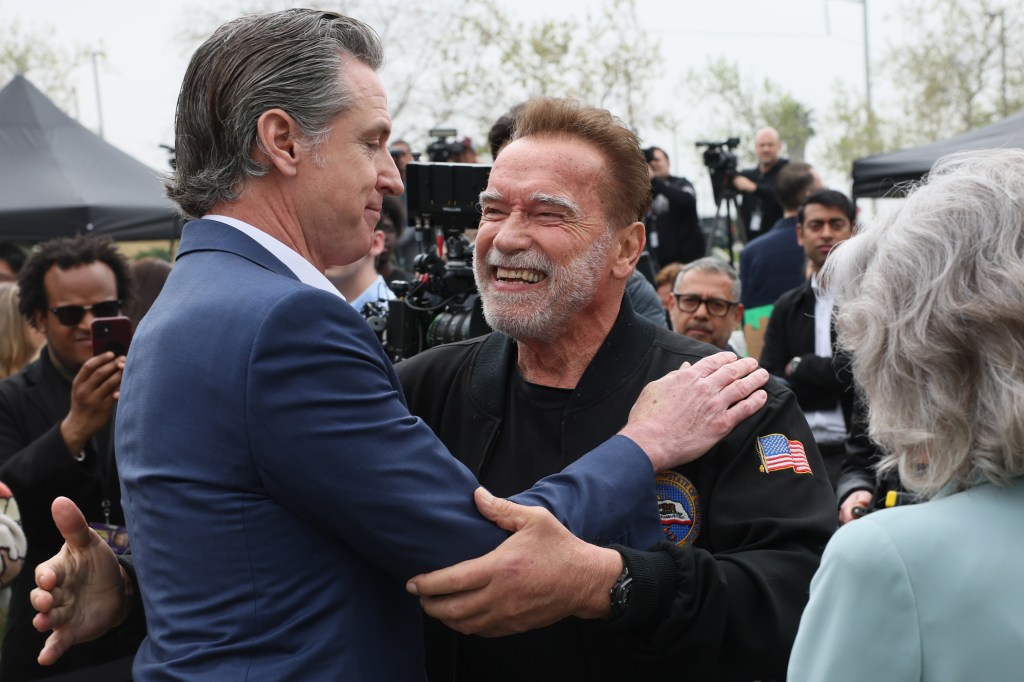 California Gov. Gavin Newsom embraces former Gov. Arnold Schwarzenegger at a news conference in Los Angeles, Calif. on March 22, 2024.