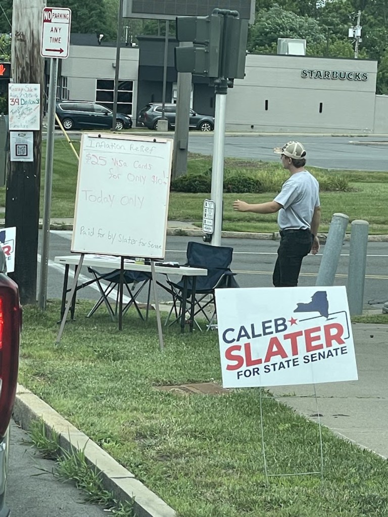 Caleb Slater for State Senate campaign sign with a table offering discounted Visa gift cards.
