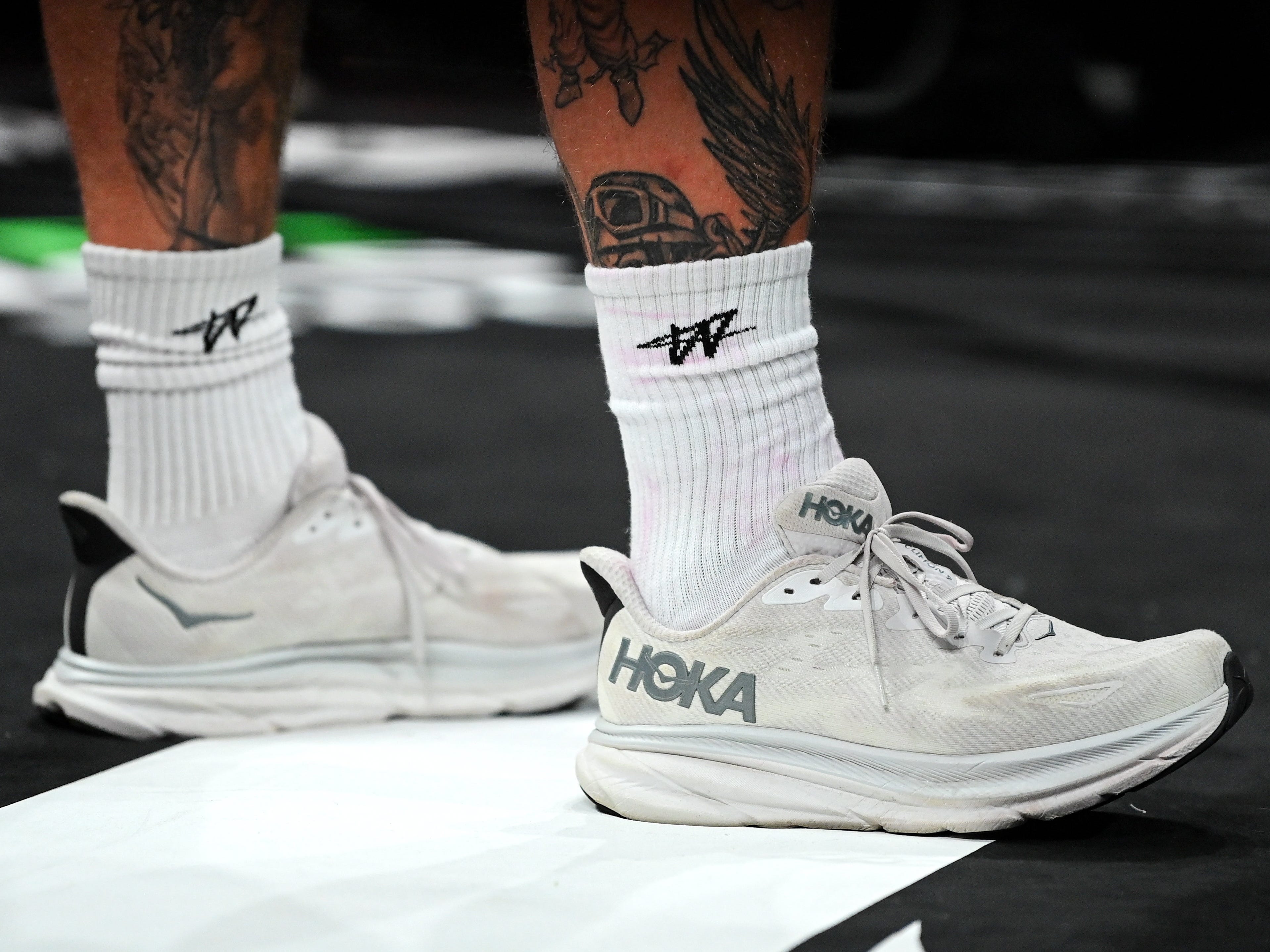 A pair of white Hoka sneakers worn by Jake Paul.