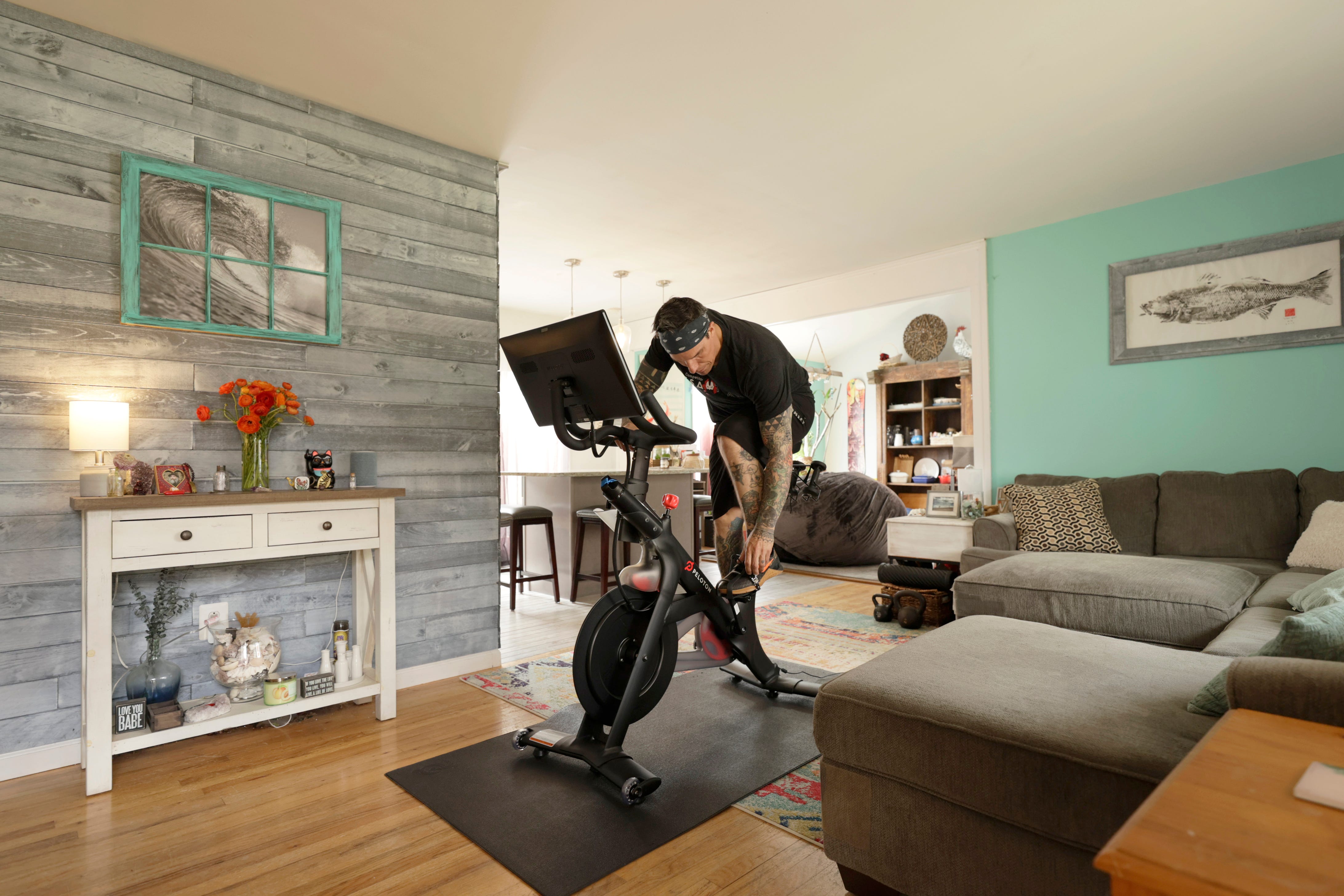 A man riding a Peloton bike in his living room.