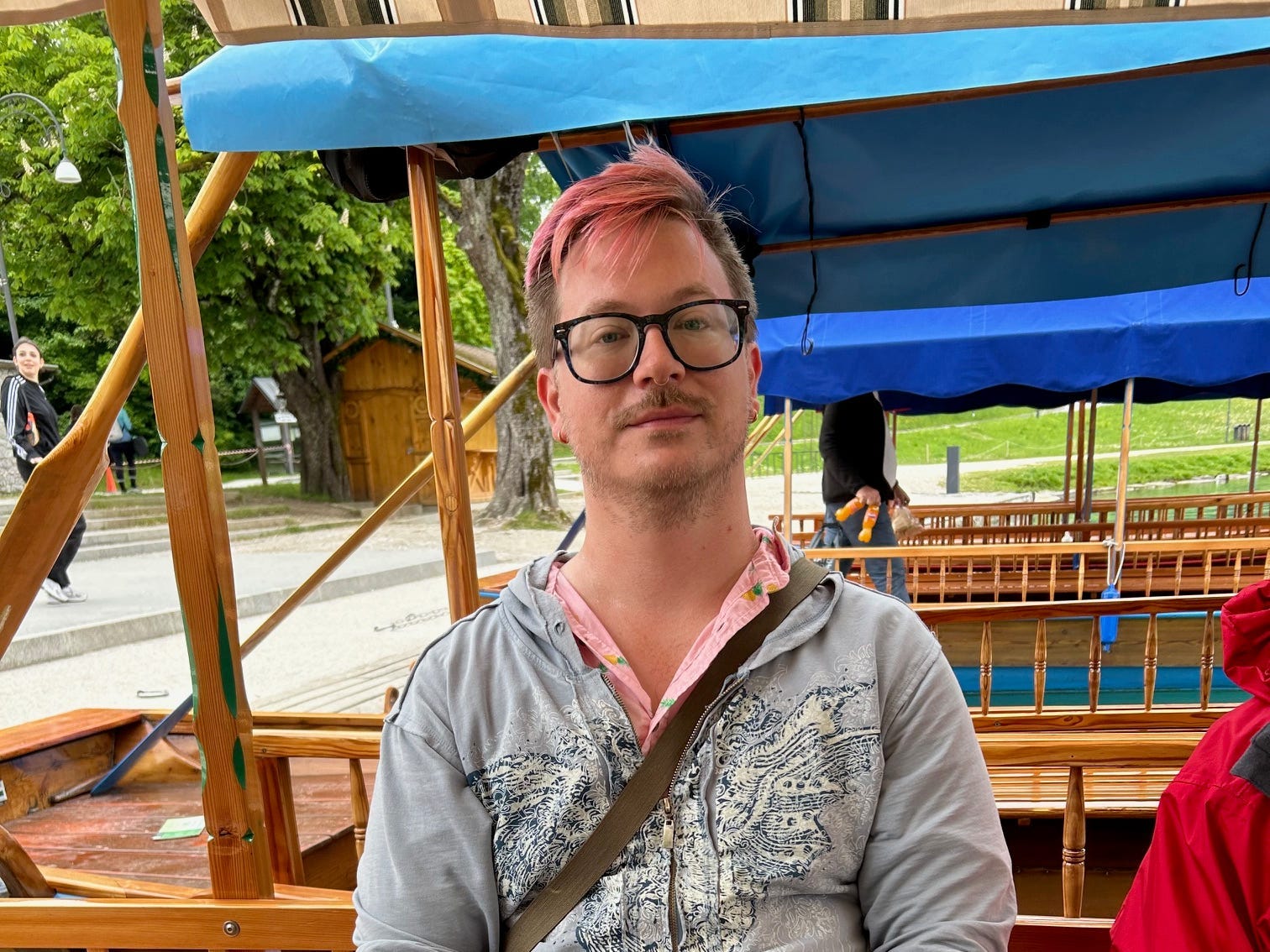 The author sitting on a wooden bench and looking at the camera.