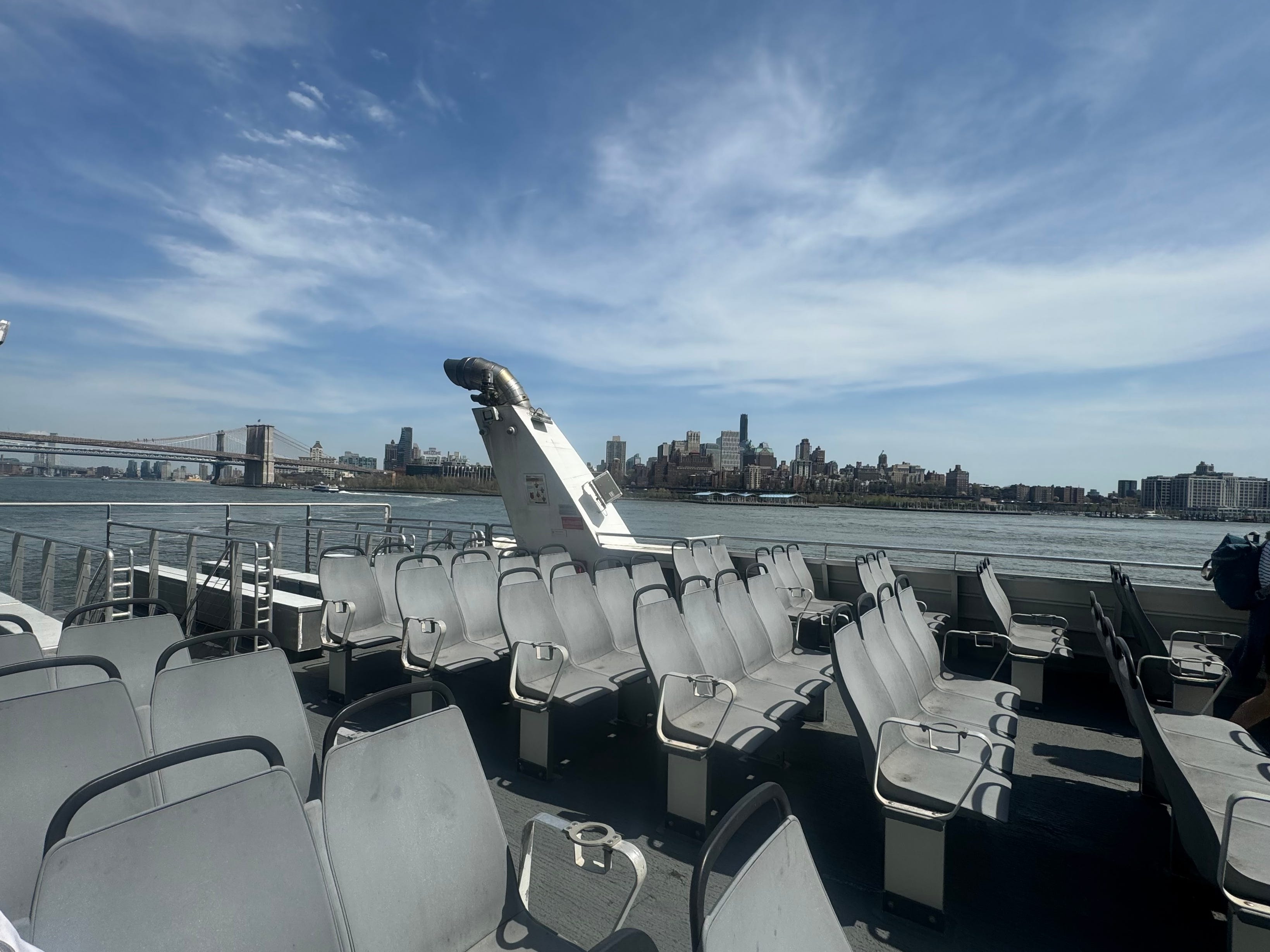 Rows of gray seats on the upper deck of the NYC Ferry.