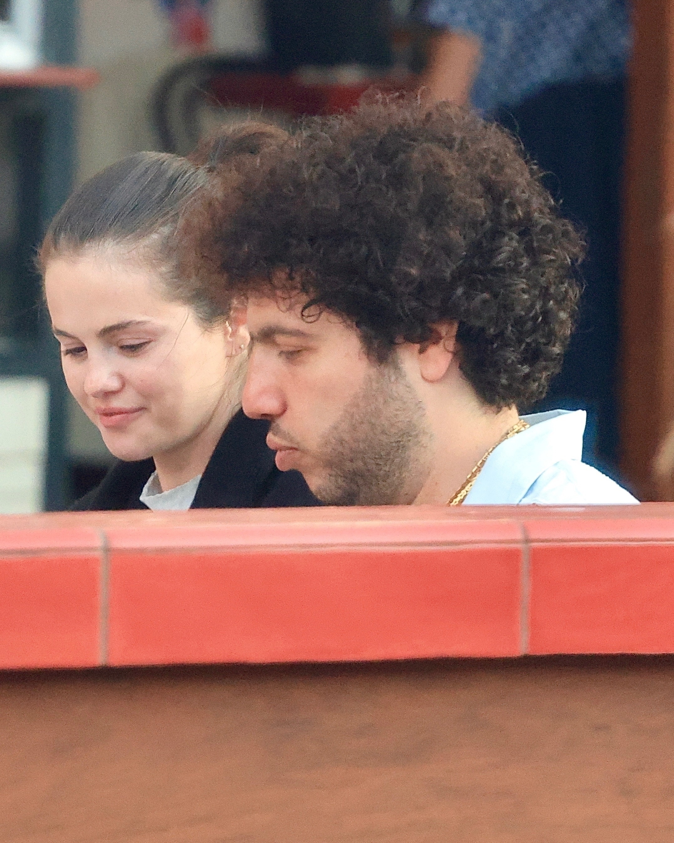 Selena Gomez and Benny Blanco sit at a table. 