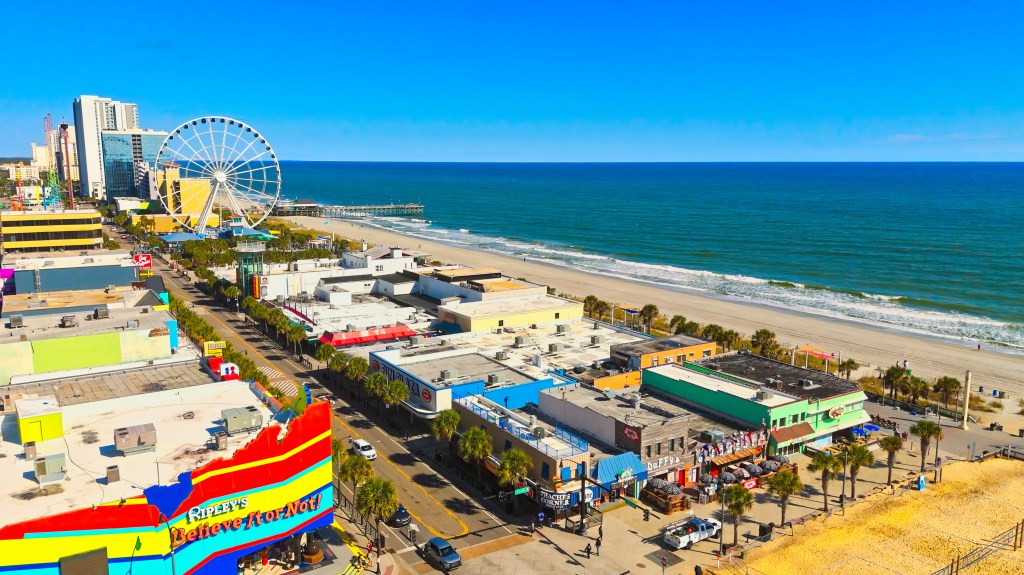 Aerial view of Myrtle Beach, South Carolina, showing the beach, ocean, boardwalk, and Ferris wheel.