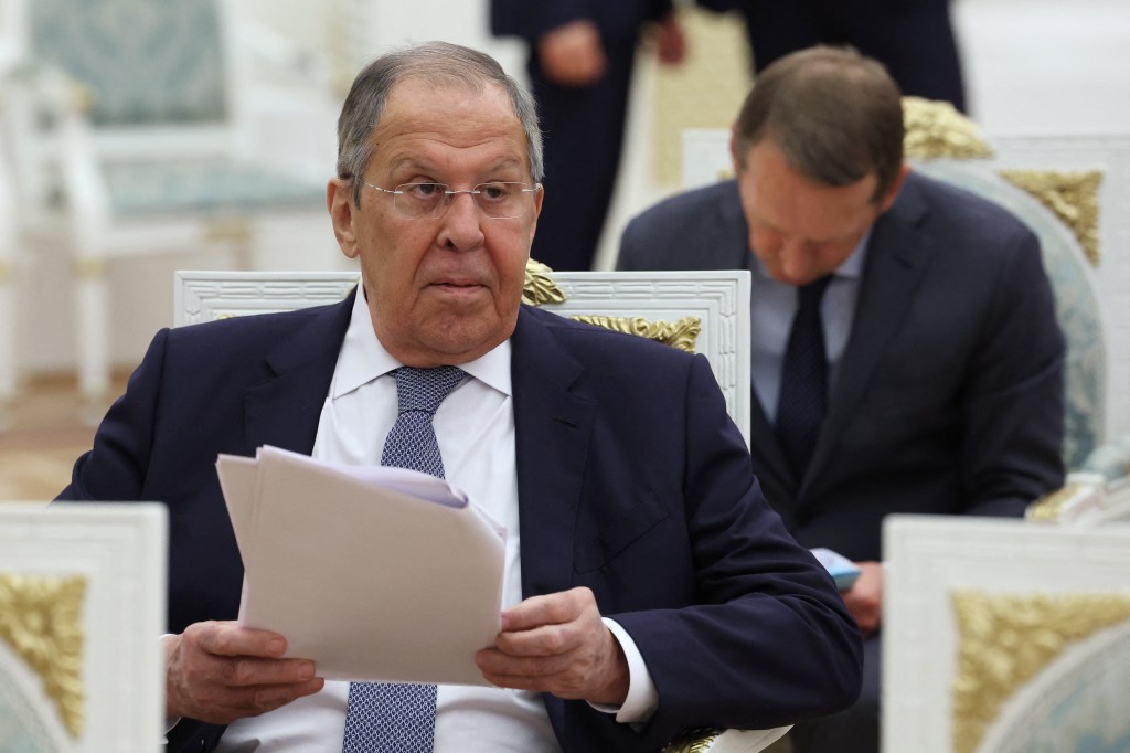 Sergei Lavrov reviewing documents at a meeting.