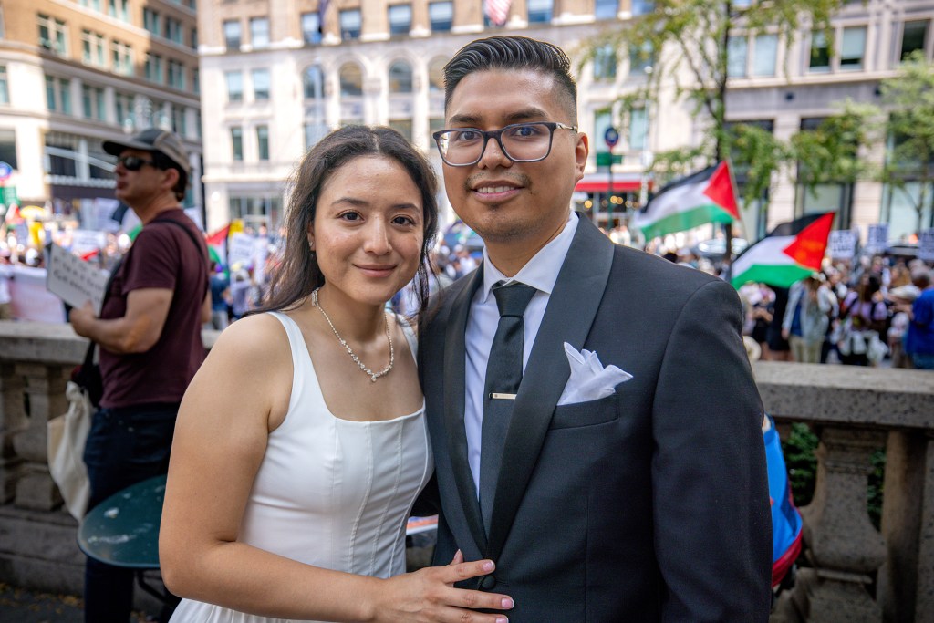 Newlyweds pose for a photo during a protest.