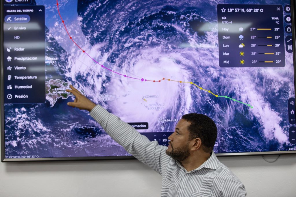 National Weather Service forecaster Wagner Rivera points to an image of Hurricane Erin in Santo Domingo, Dominican Republic on August 16, 2025.