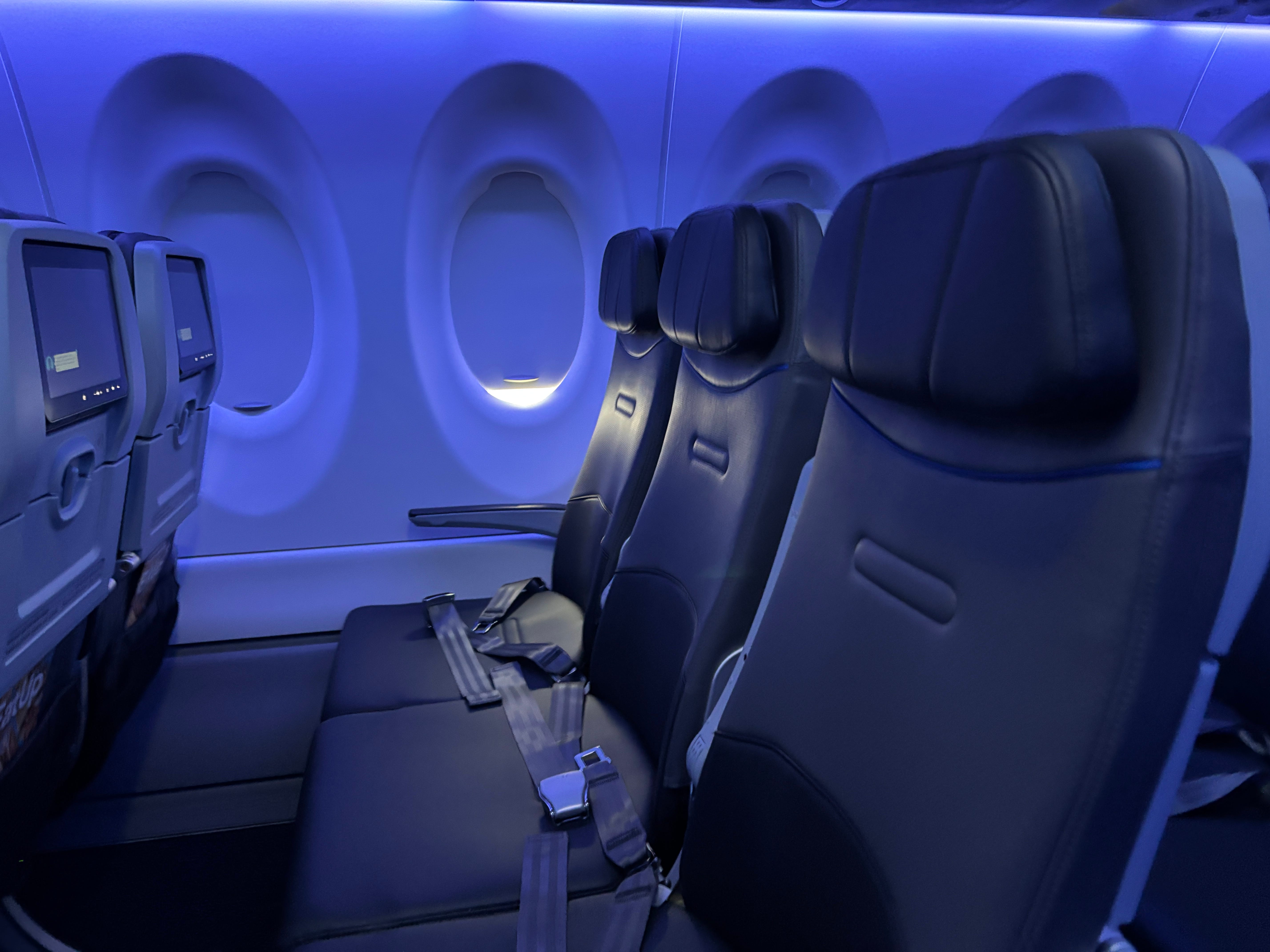 A row of three economy seats on board a JetBlue Airbus A220