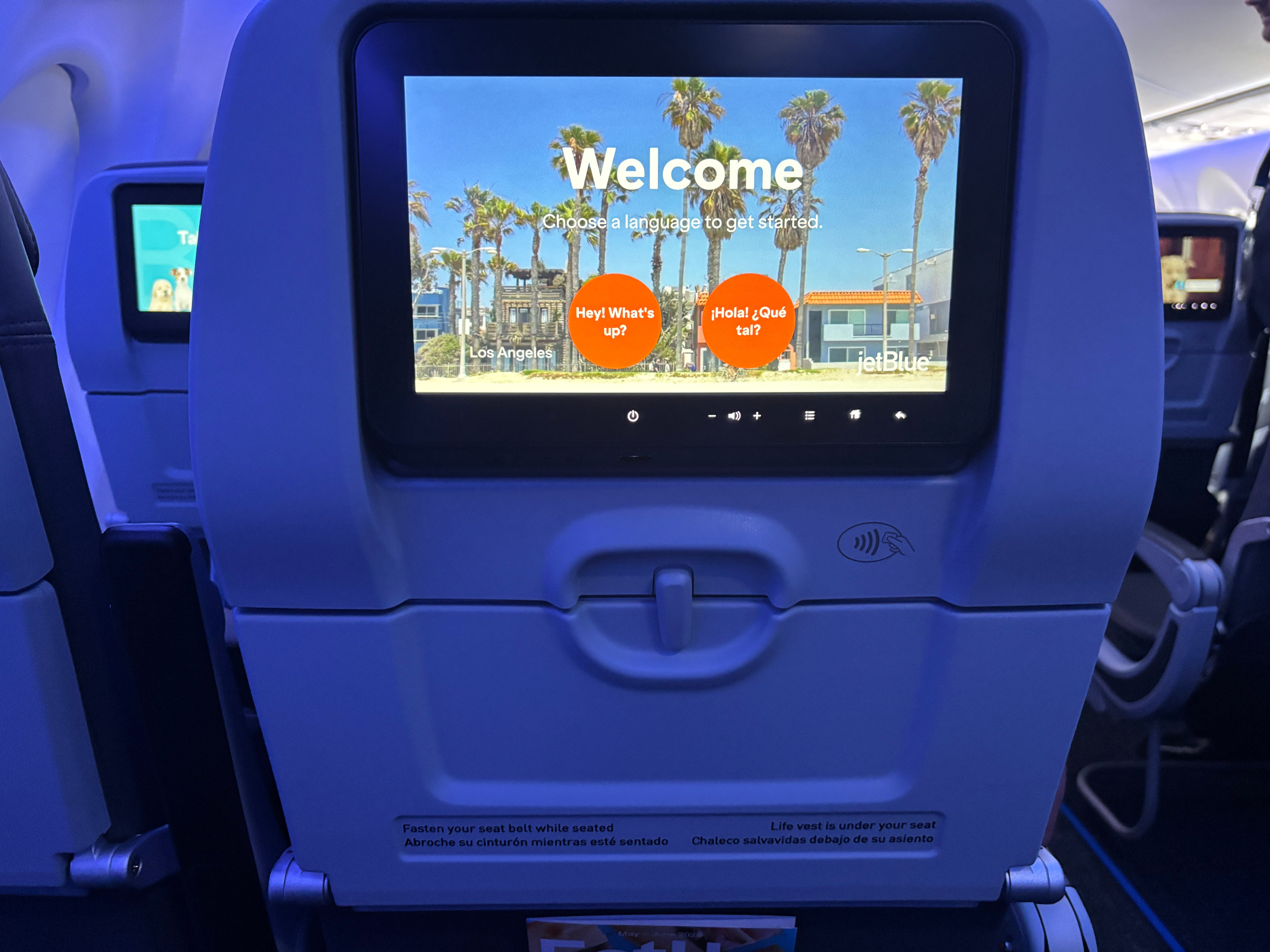 A close-up of the entertainment screen on board JetBlue Airbus A220