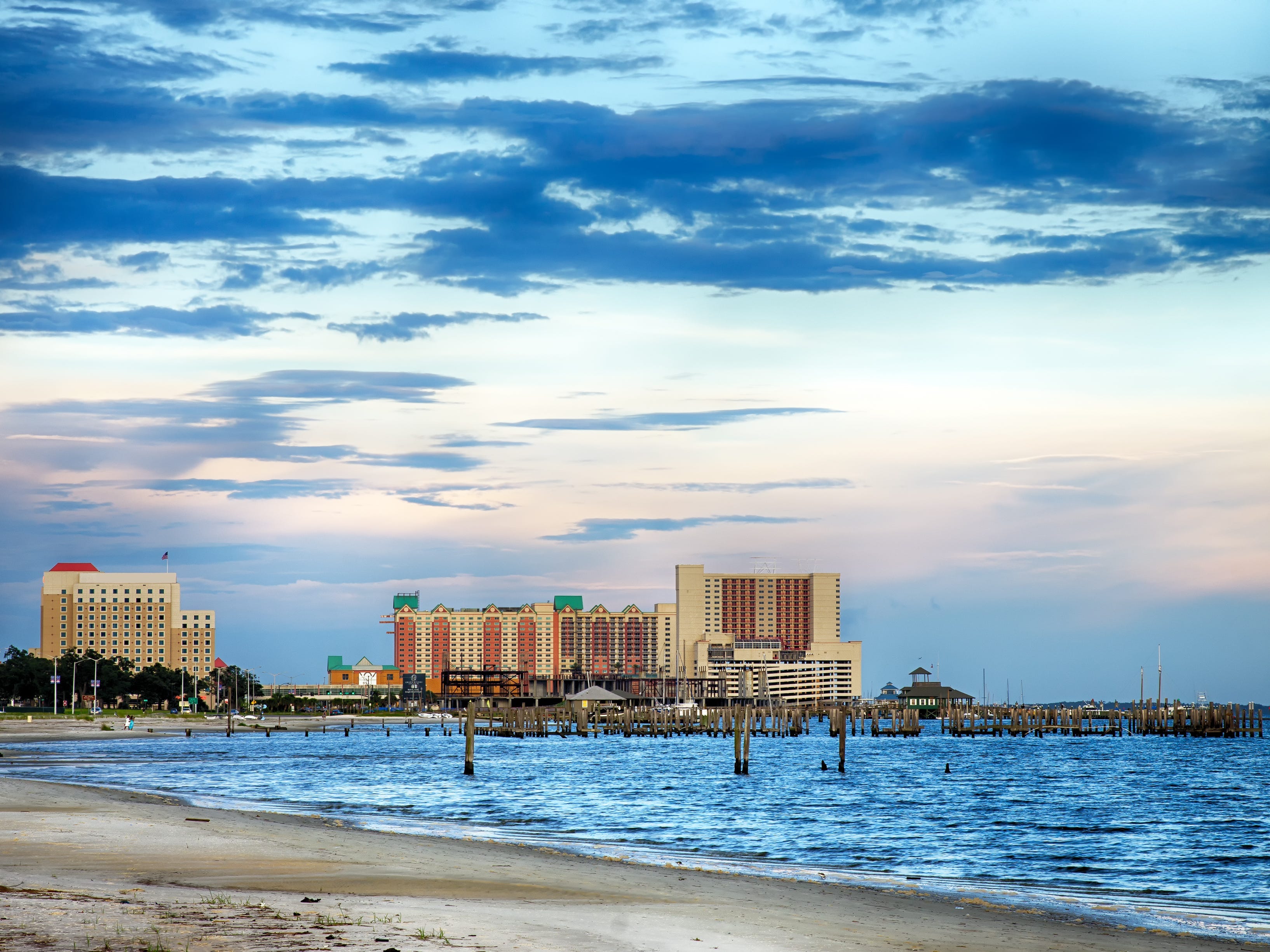 Casinos and buildings along the Gulf Coast shore at sunset.