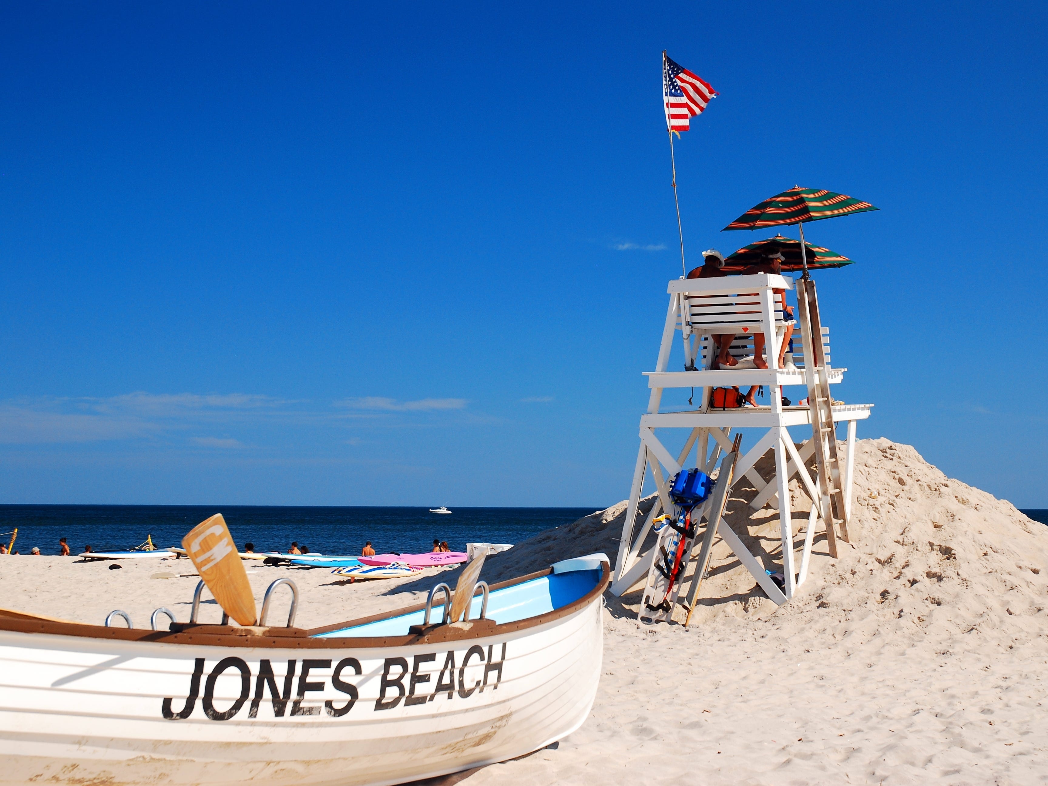 A lifeguard rescue row boat stands behind the lifeguard tower at Jones Beach State Park in New York.