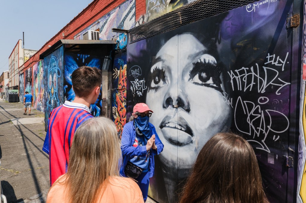 A guide leads a small group on a graffiti tour.