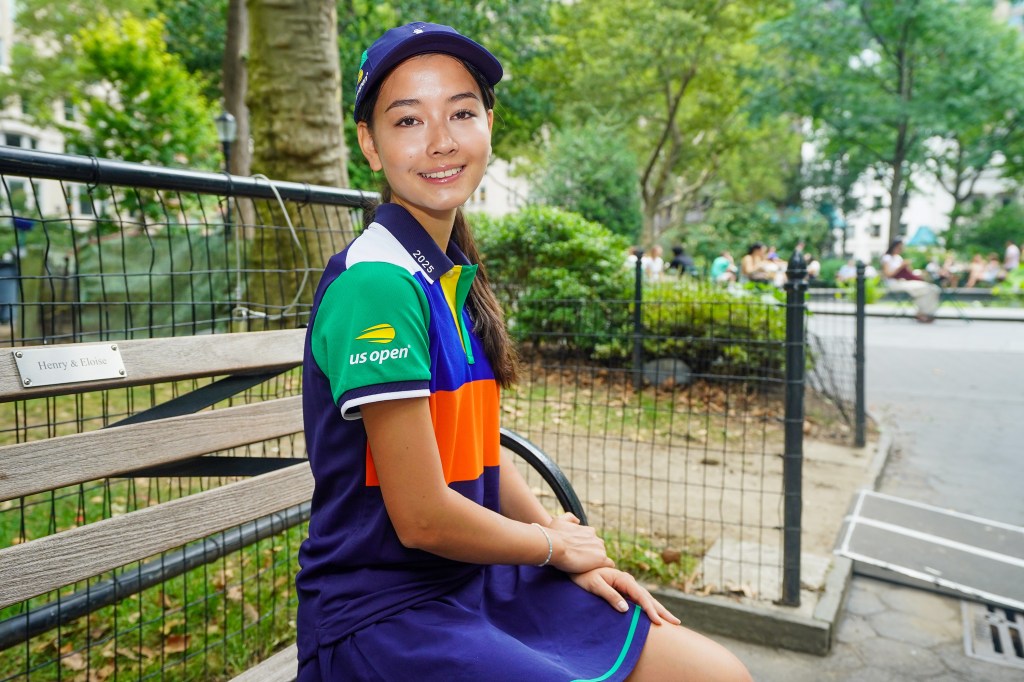 Akari Weintzen, a US Open ball runner, sits on a bench.