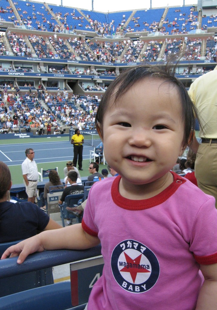 Smiling young girl at a tennis match.
