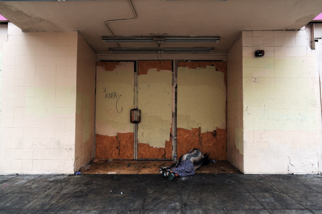 A homeless person sleeping outside of an abandoned building in DTLA.