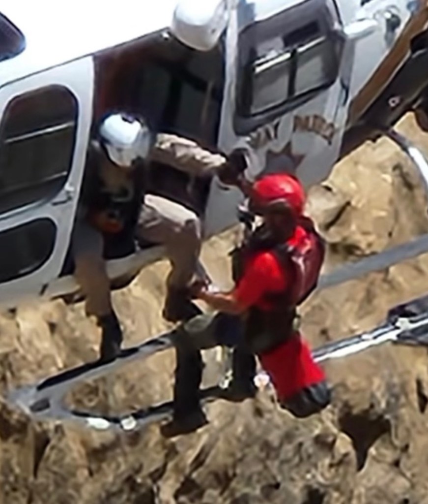 Rescue personnel assisting someone from a helicopter.