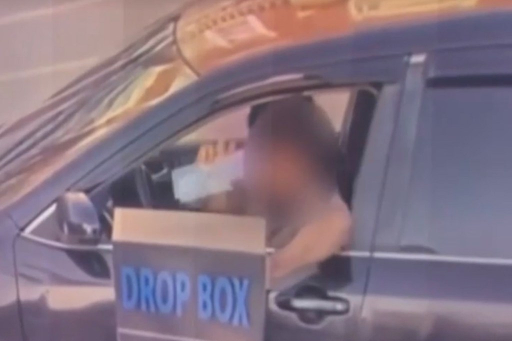 Person depositing ballots into a drop box.