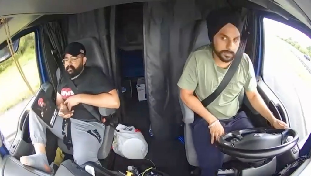 Two men in the cab of a semi-truck.